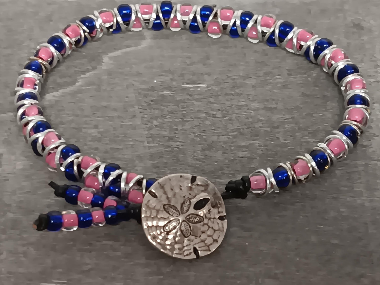 Cast metal shank button beaded bracelet, on leather cord. Glass bracelet, shank button bracelet.