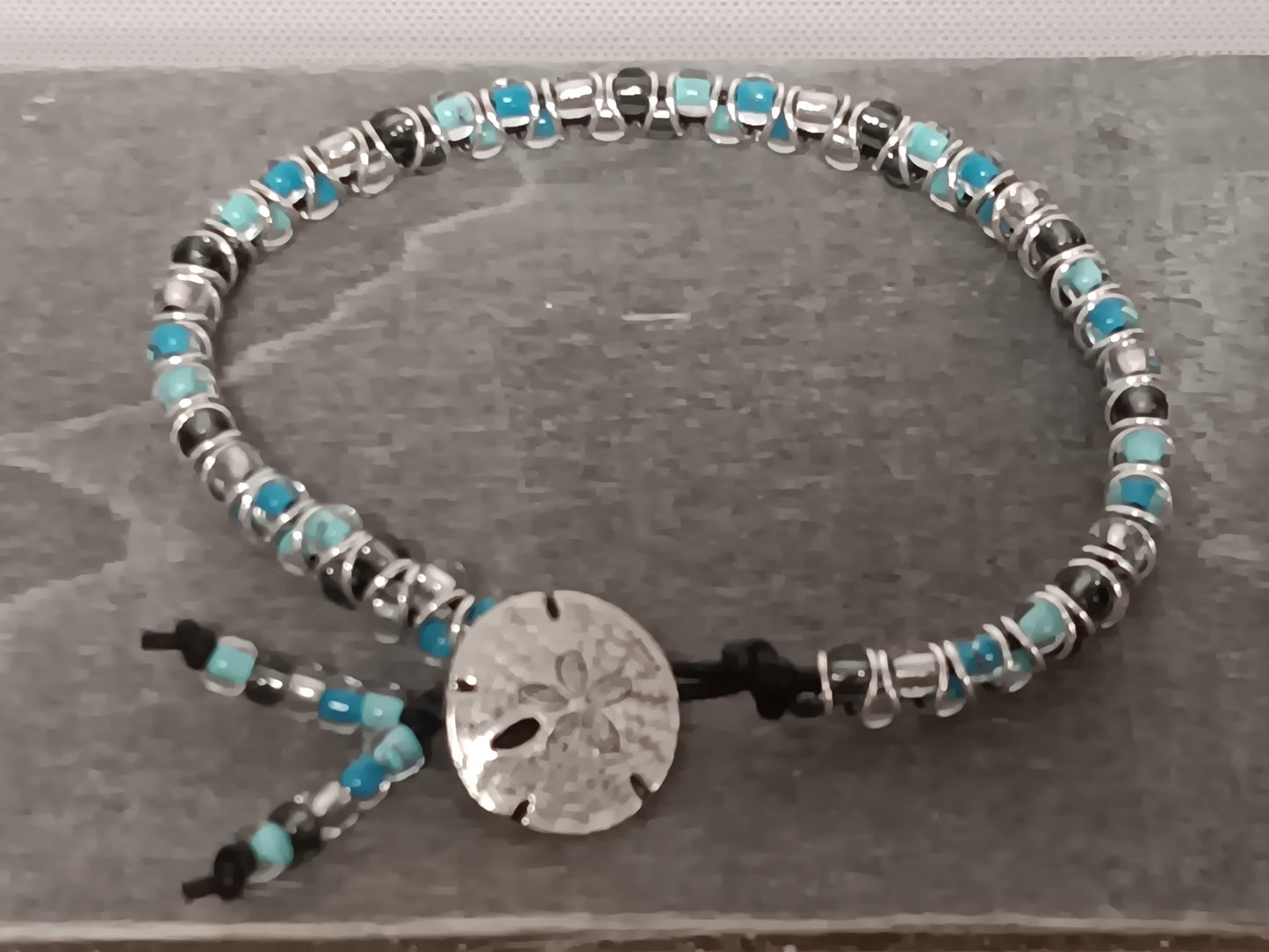 Cast metal shank button beaded bracelet, on leather cord. Glass bracelet, shank button bracelet.