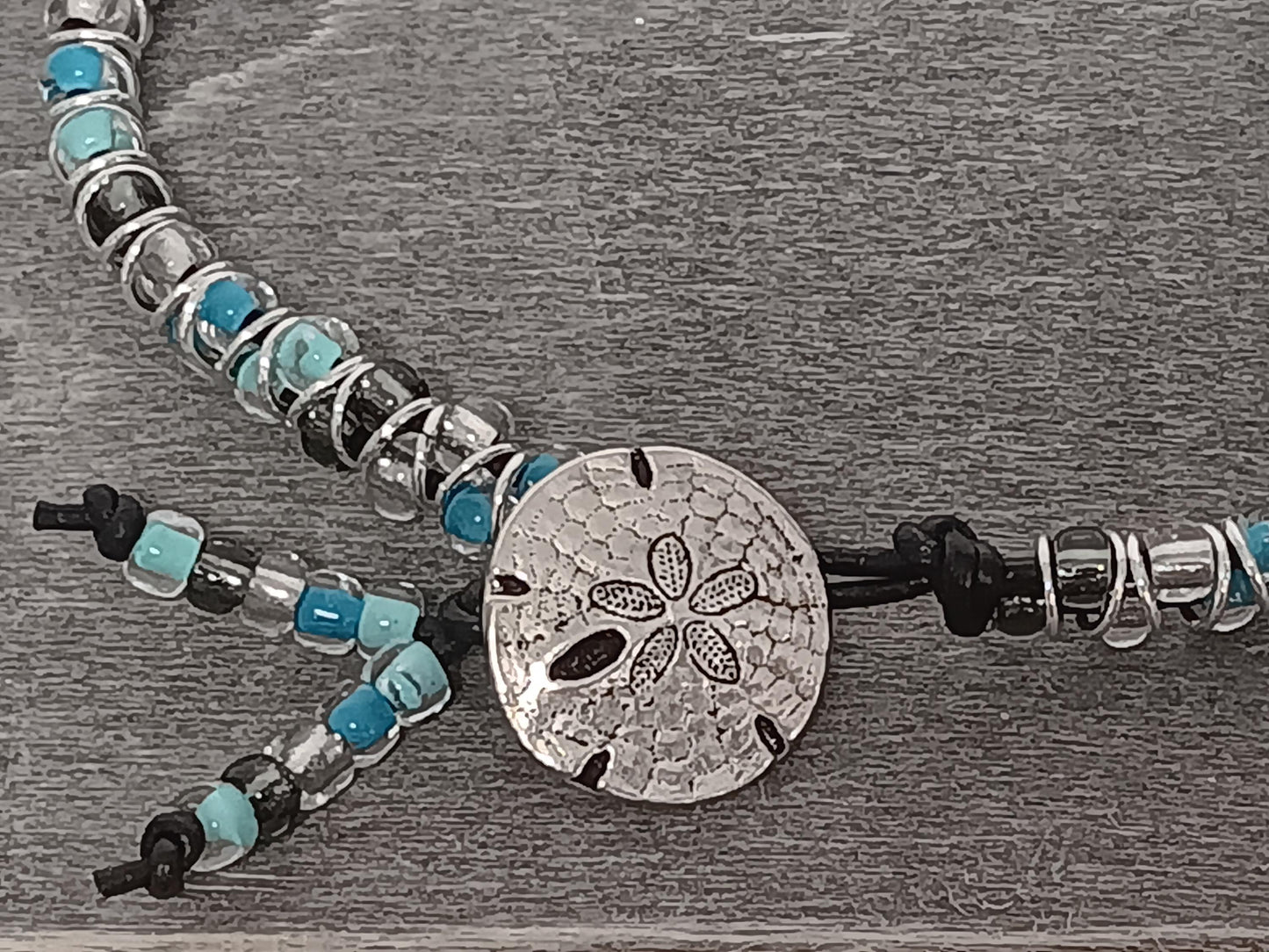 Cast metal shank button beaded bracelet, on leather cord. Glass bracelet, shank button bracelet.