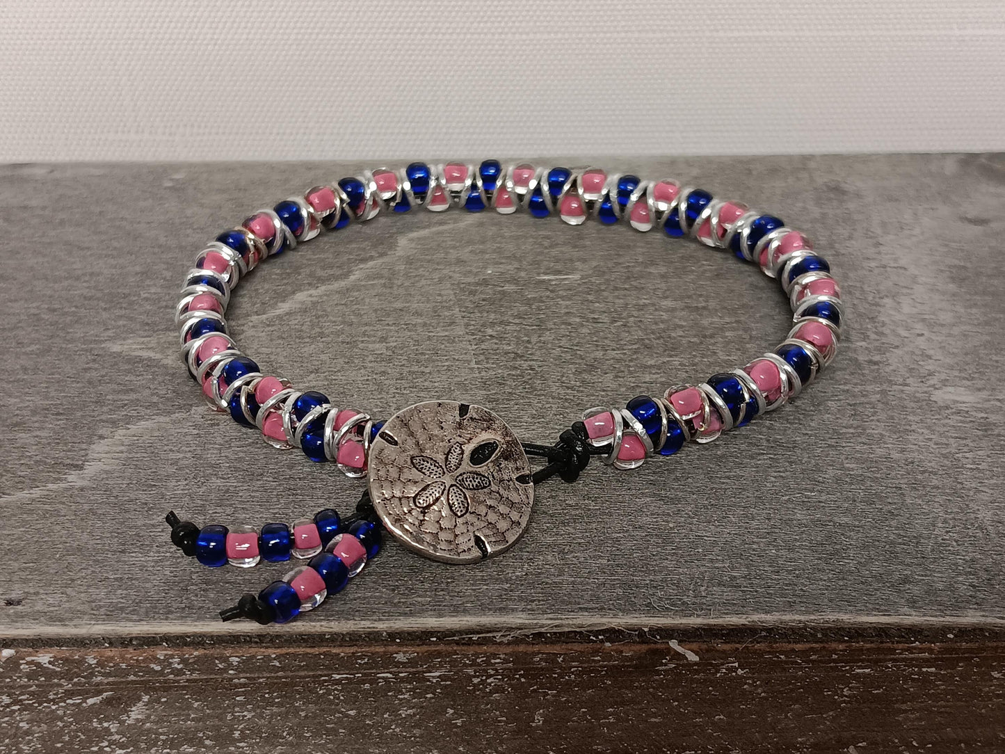 Cast metal shank button beaded bracelet, on leather cord. Glass bracelet, shank button bracelet.
